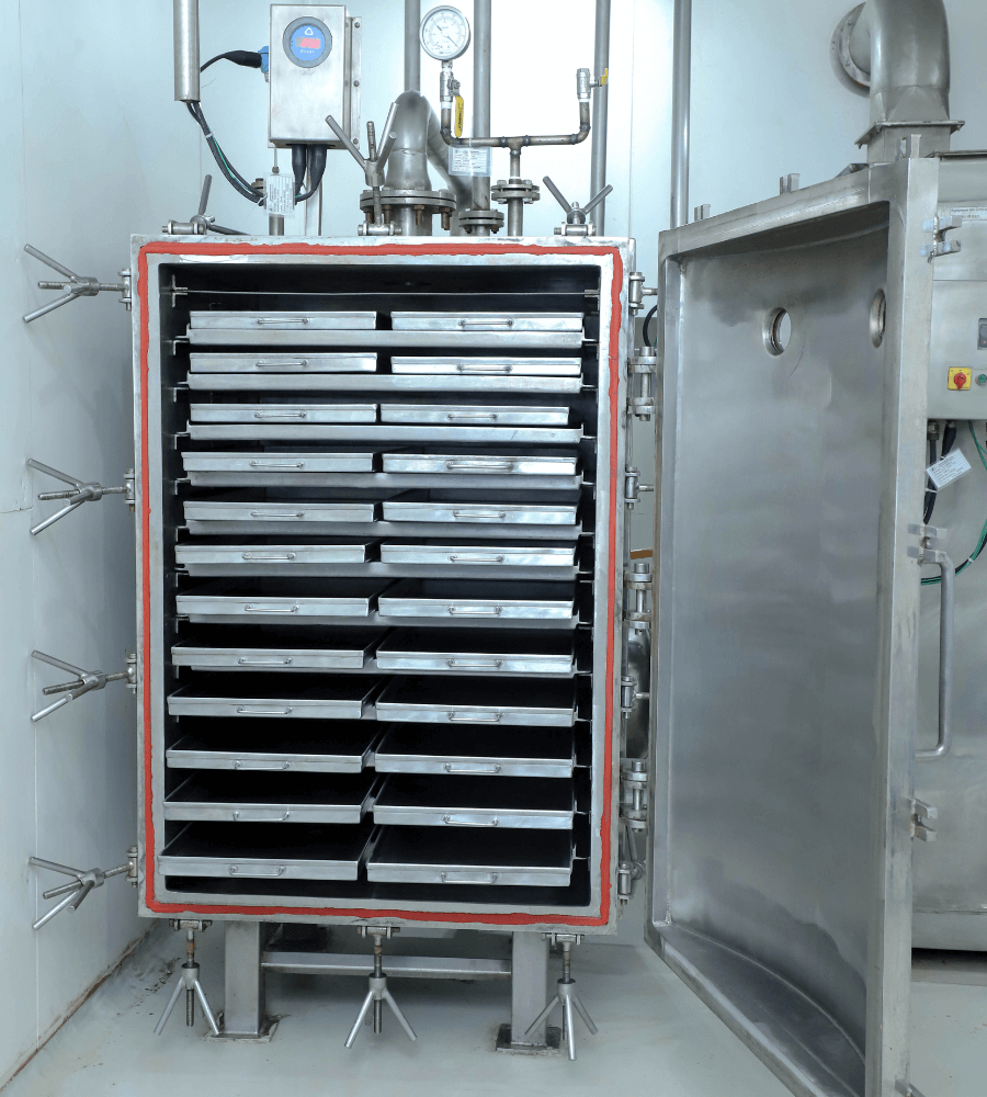 Vacuum tray dryer with its door open, showcasing multiple trays for drying products