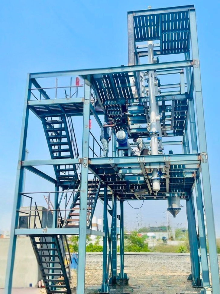 Industrial MEE plant under installation, workers assembling multiple effect evaporators for energy efficiency