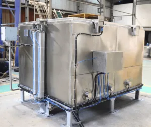 Industrial quench tank with automated cooling system, designed for efficient heat treatment in manufacturing